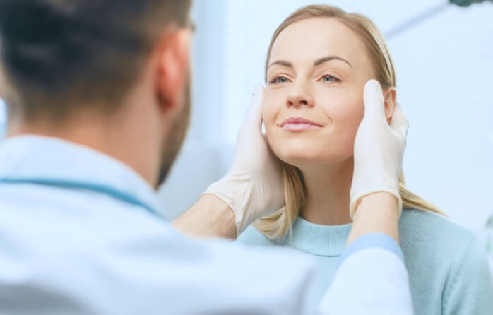 woman inspecting patients face